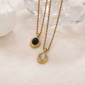 Detailed view of vintage gold necklaces with black and white cat eye oval pendants