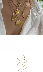 Detailed view of multiple 18K gold plated ocean-themed pendant necklaces on a model