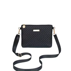 Detailed view of a stylish black chevron quilted crossbody bag with gold hardware