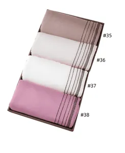 Close-up of four mercerized cotton scarves with diamond trim in a gift box display