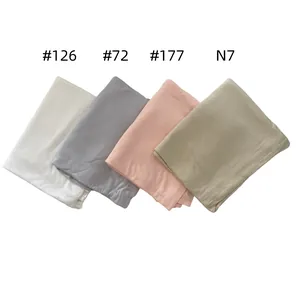 Detail showing mercerized cotton scarves in cream, grey, pink, and olive green textures