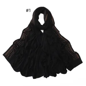 Detail of soft black jersey scarf with elegant gold rhinestone stripes decor