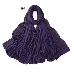 Detailed view of dark purple jersey scarf featuring parallel golden rhinestone borders