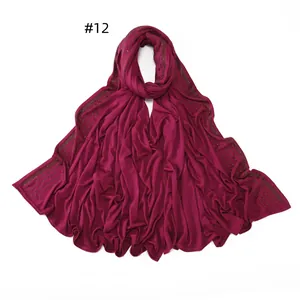 Detailed view of burgundy cotton scarf featuring golden rhinestone border and soft fabric