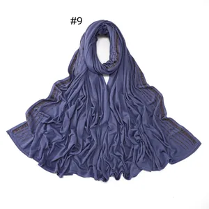 Detail of blue-purple jersey scarf featuring sparkling diamond-like rhinestones