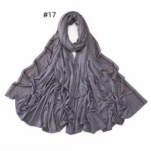 Detail of dark grey jersey scarf featuring parallel rows of brown sparkling rhinestones