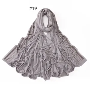 Detailed view of light grey jersey scarf featuring parallel rows of dark rhinestones