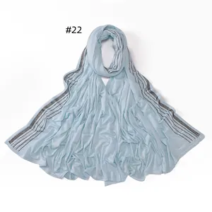 Detail of light blue mercerized cotton scarf with five rows of black rhinestone stripes