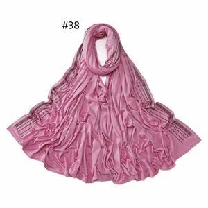 Detail of pink mercerized cotton scarf with five rows of sparkling black rhinestones