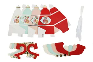 Detailed view of teapot shaped paper candy box components with gold foil and ribbons