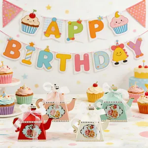 Teapot-shaped party favor boxes with floral designs and white ribbons for weddings