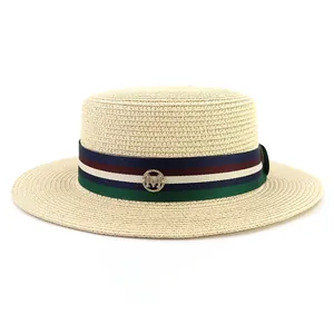 Flat top beige straw boater hat with striped ribbon and gold M logo for summer
