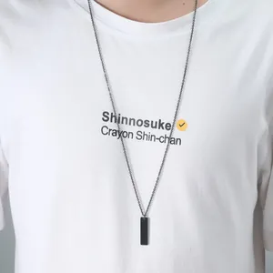 Stainless steel rectangular bar pendant necklace on a long chain worn over a white shirt.