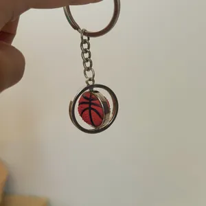 Close-up of a rotating basketball keychain with a polished silver metal ring and red ball