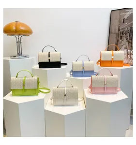 Variety of candy-colored woven patchwork crossbody bags for women displayed on pedestals.