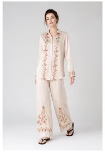 Detailed view of floral satin pajama set featuring elegant embroidery on champagne fabric
