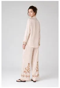 Elegant champagne satin pajama set with floral embroidery on cuffs and hemline.