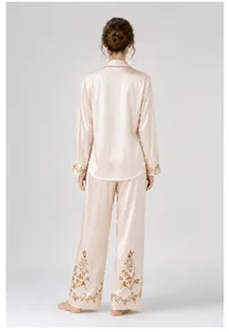Back view of champagne satin pajama set with floral embroidery details on hems.