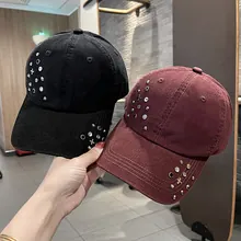 Pair of black and burgundy studded baseball caps with metallic rhinestone patterns.