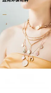 Close-up detail of a layered gold chain necklace with decorative coin and hamsa charms.
