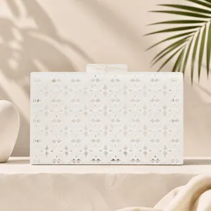 Elegant white lace acrylic evening clutch bag with marble clasp in sunlit studio
