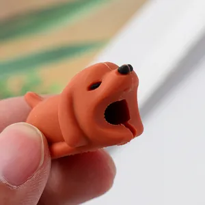 Close-up view of a cute brown dog-shaped silicone cable protector being held by hand