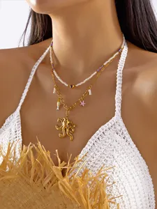 Detalle de primer plano del collar bohemio dorado con dijes de pulpo y perlas