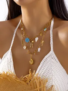 Primer plano de un collar bohemio dorado a capas con varios dijes de conchas