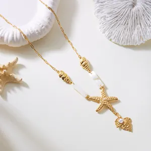 Detalle de dijes de estrella de mar y caracolas doradas en collar de estilo bohemio