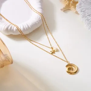 Detalle del collar dorado de dos capas con colgantes de concha y estrella de mar