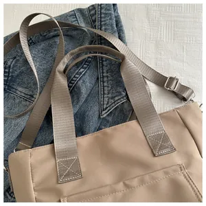 Detailed shot of khaki nylon tote bag showing straps and durable fabric texture