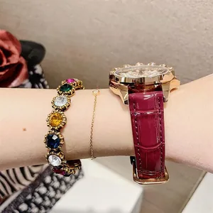 Close-up of luxury burgundy leather watch with diamond bezel and matching bracelets