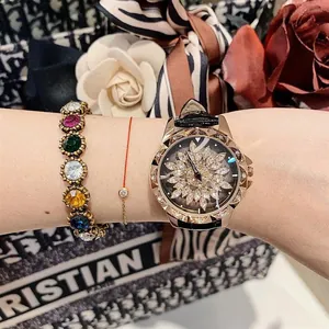 Detail of a rotating diamond flower watch with rose gold case and leather strap