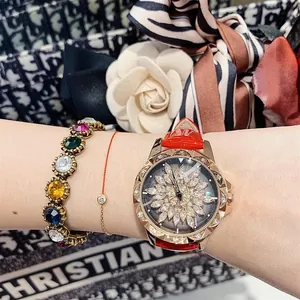 Close-up of red leather watch with rotating crystal flower dial and gemstone bracelets