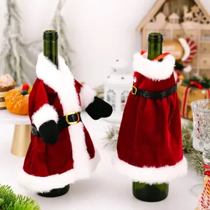 Festive Santa Claus style red velvet wine bottle covers for Christmas table decor.