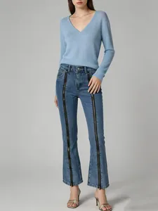 Detailed view of women's blue flare jeans featuring unique vertical zipper design on legs