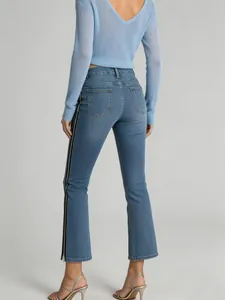 Detail of women's light blue flared jeans featuring a unique side zipper design.