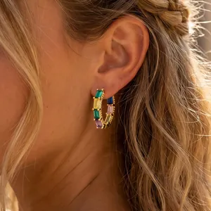 Detail shot of colorful zircon hoop earrings on ear, 18K gold plated minimalist jewelry.
