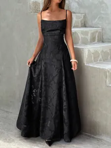 Robe longue noire élégante à fines bretelles présentant un motif jacquard rose texturé
