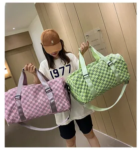 Close-up detail of large capacity checkered travel duffel bags in pink and green