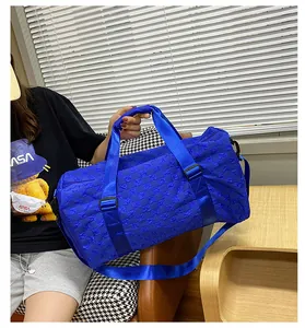 Large capacity travel duffel bag with blue checkerboard texture shown on model