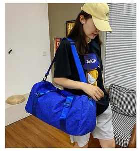 Detail view of the large blue checkered travel bag being worn as a crossbody bag