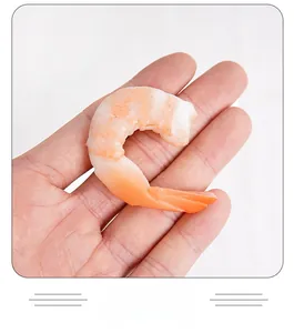 Detailed view of a realistic PVC shrimp tail model held in hand for size display