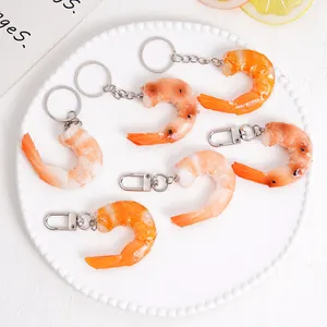 Set of 6 realistic PVC cooked shrimp keychains with metal carabiners on a white plate