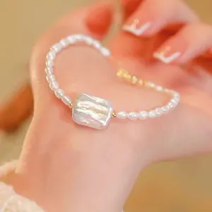 Gros plan d'un élégant bracelet en perles d'eau douce avec une perle baroque carrée