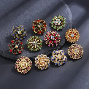 Detailed close-up of vintage floral alloy brooches with colorful rhinestones on stone