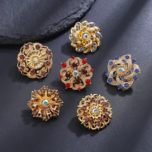 Macro detail of six vintage alloy floral brooches with colorful rhinestones on stone