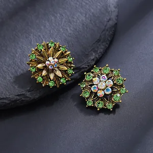 Macro shot of vintage gold flower earrings with green rhinestones and AB crystals