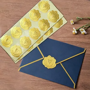 Close-up detail of golden heart wax seal stickers applied on a navy blue envelope