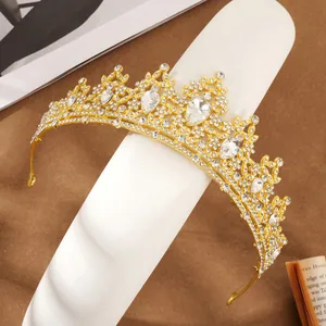 Close-up of golden bridal crown with sparkling crystal rhinestones on display stand